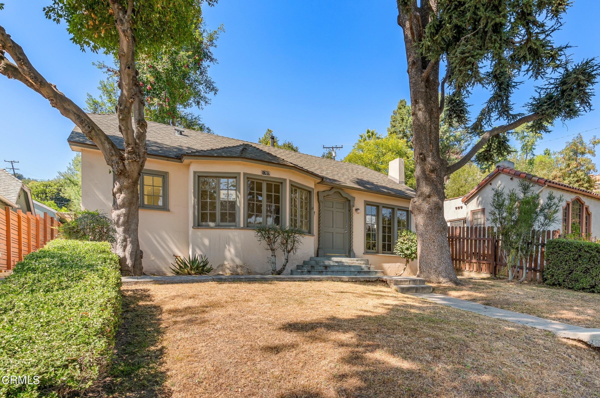 a front view of a house with a yard and potted plants