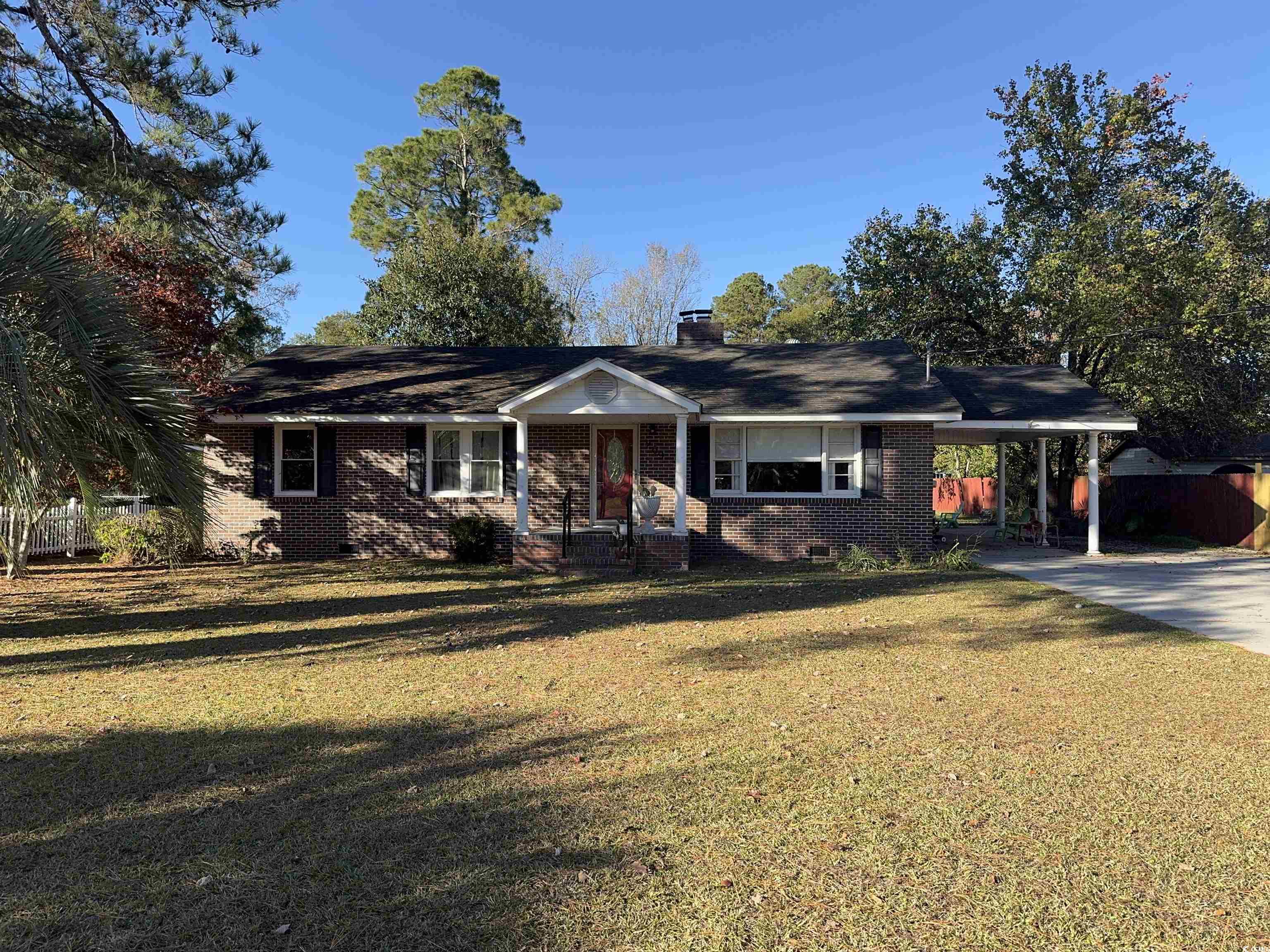 Ranch-style home with a front lawn and a carport