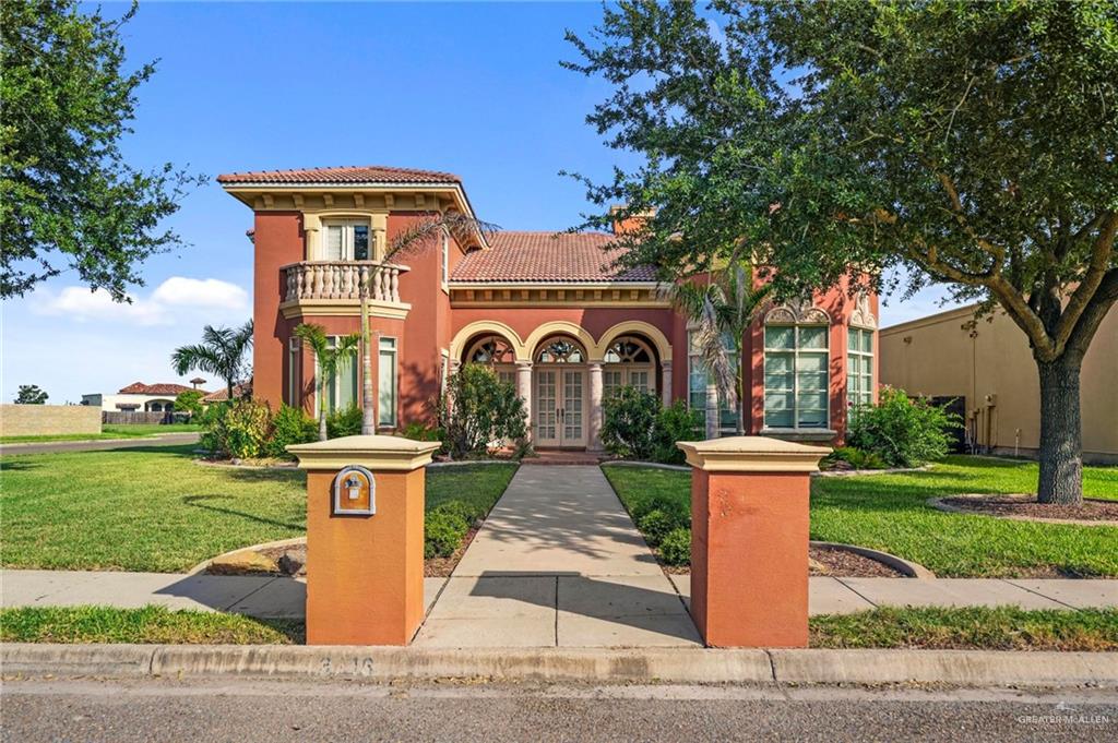 Mediterranean / spanish house with a front lawn and a balcony