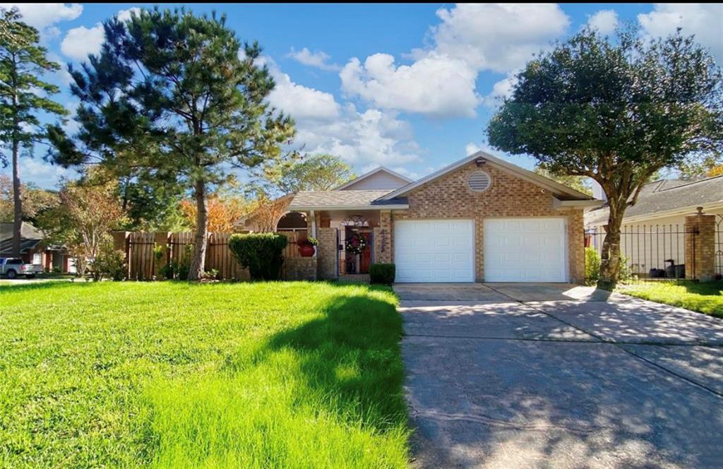 a view of a house with a yard and large tree