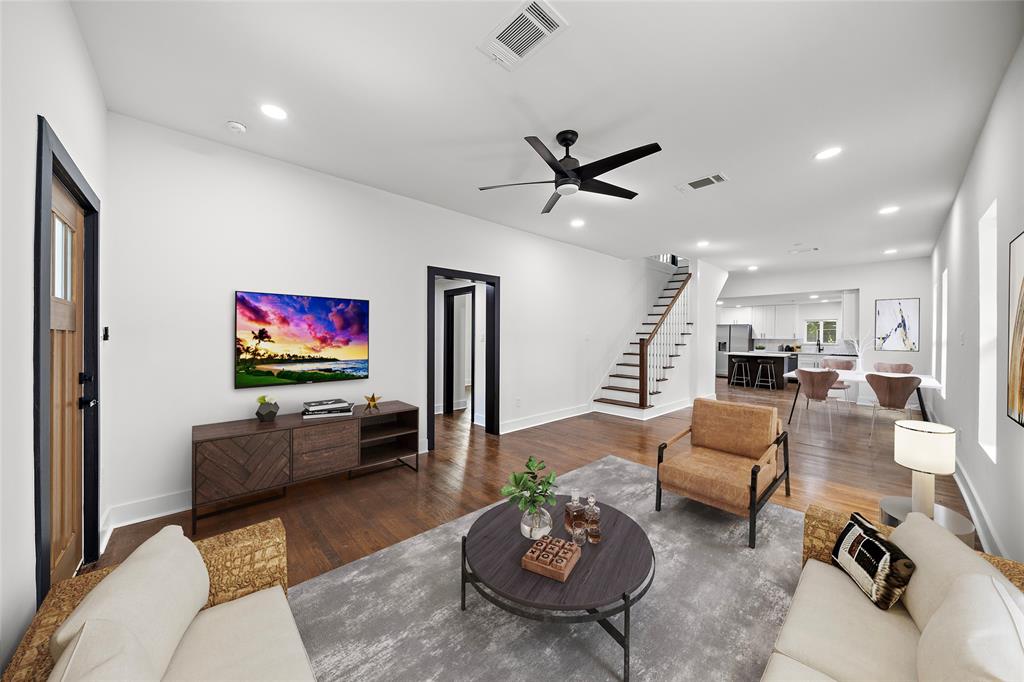 a living room with furniture kitchen view and a flat screen tv