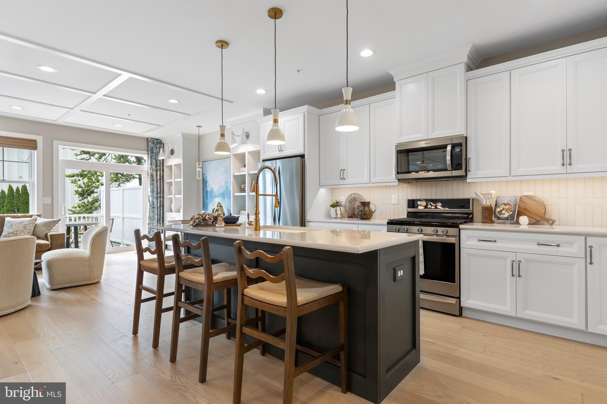 a kitchen with kitchen island granite countertop a sink and a refrigerator