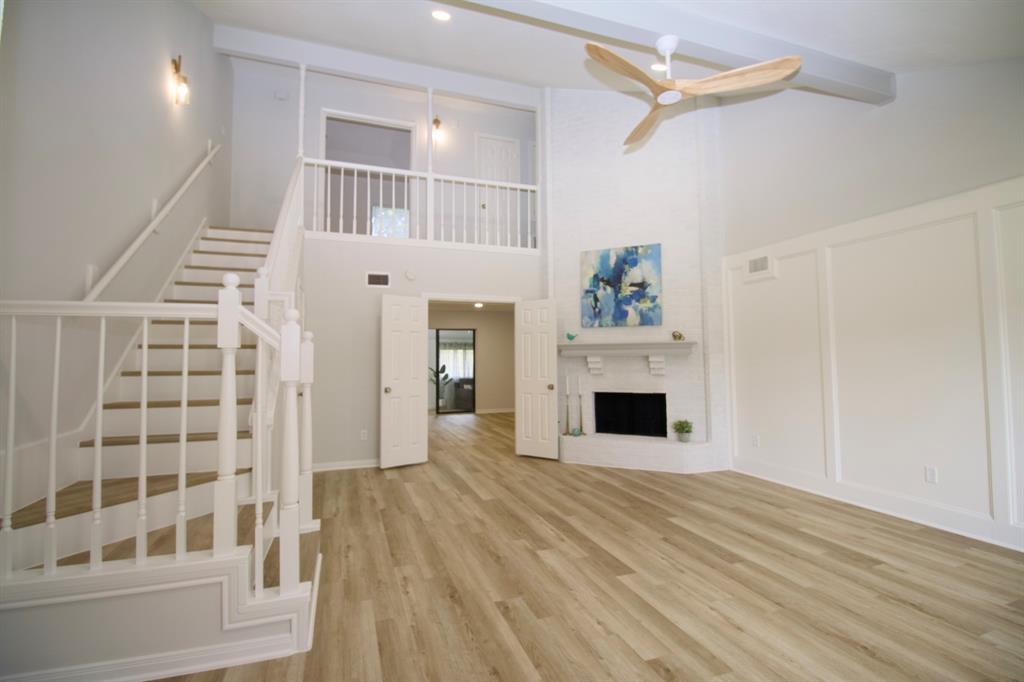 a view of a livingroom with wooden floor and a fireplace