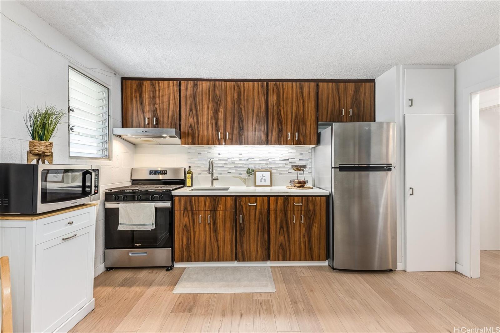 a kitchen with a refrigerator a stove a sink and a window