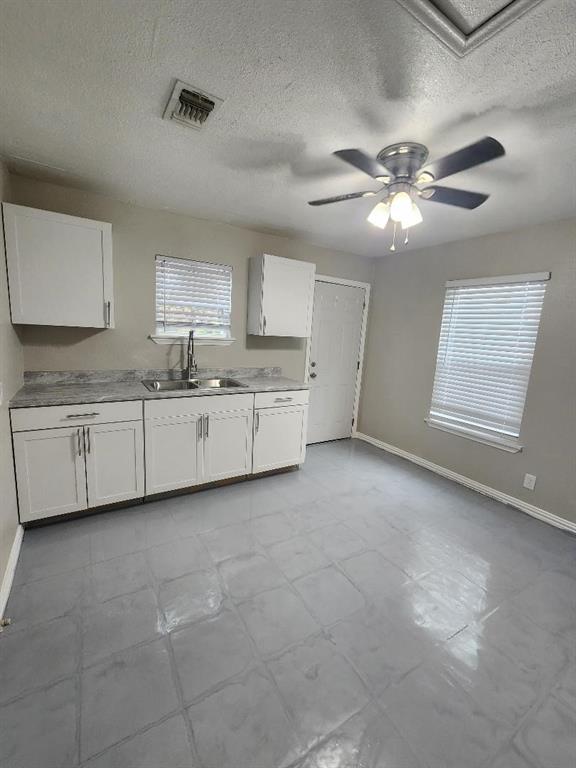 a large white kitchen with a sink stainless steel appliances and cabinets