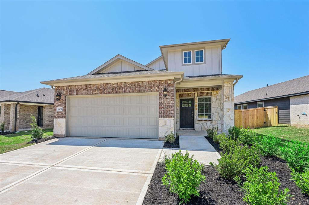 a front view of a house with a garage and a yard