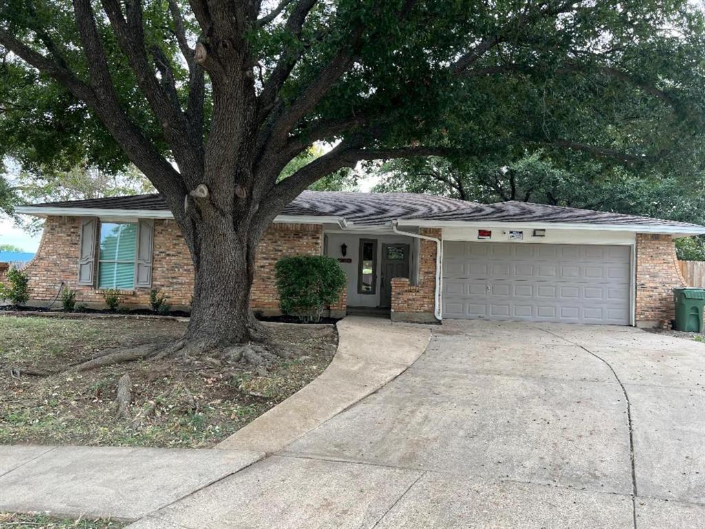 front view of the house with a yard and an trees