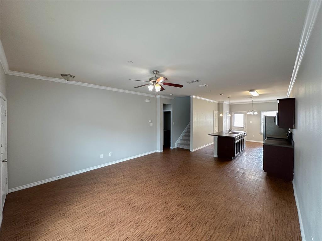 a view of a livingroom with a ceiling fan window and a kitchen