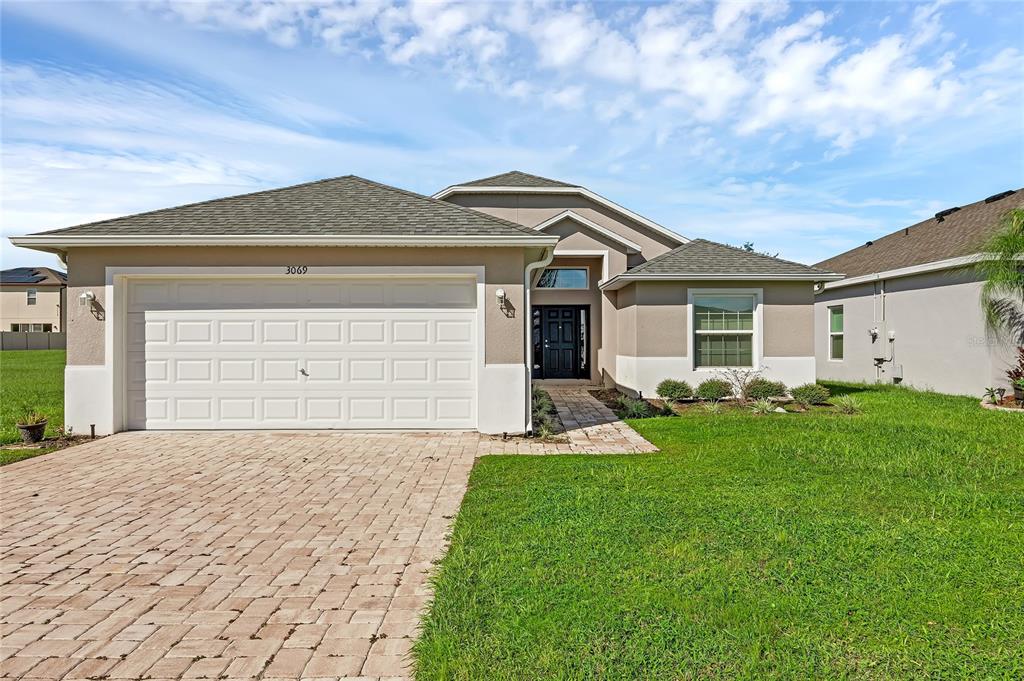 a front view of a house with a yard and garage