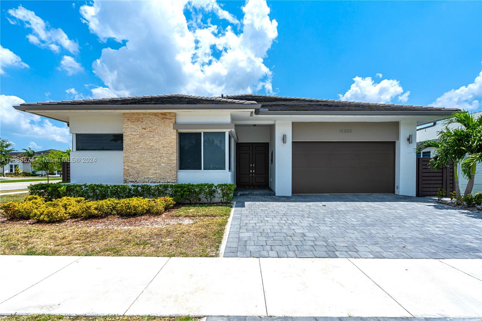 a front view of a house with a yard and a garage