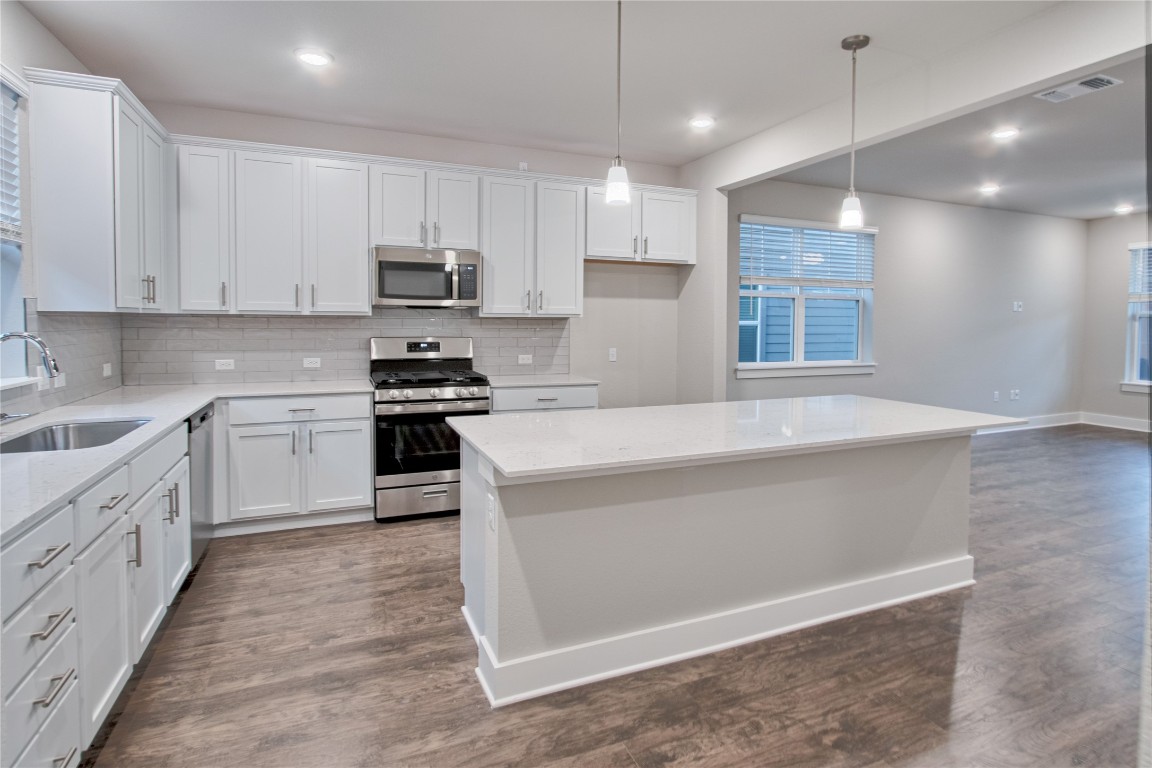 a kitchen with white cabinets and appliances