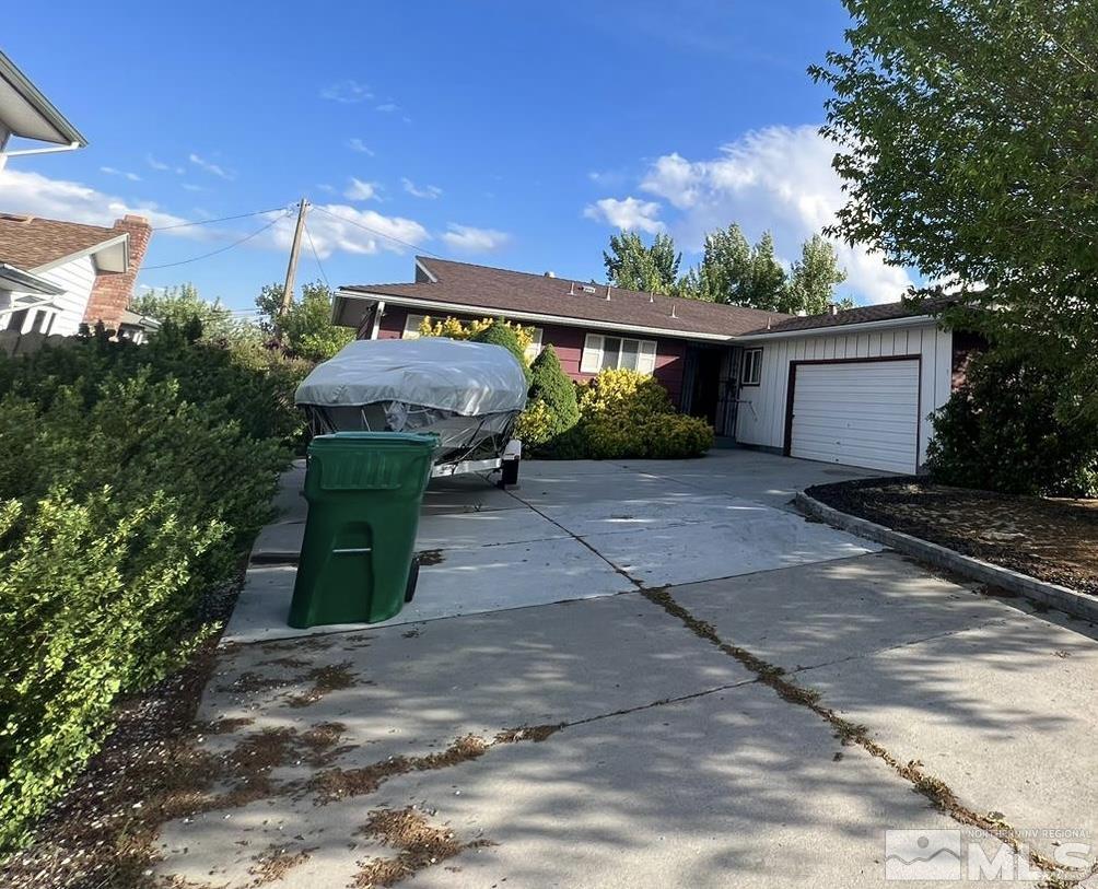 a front view of house with yard and trees in the background