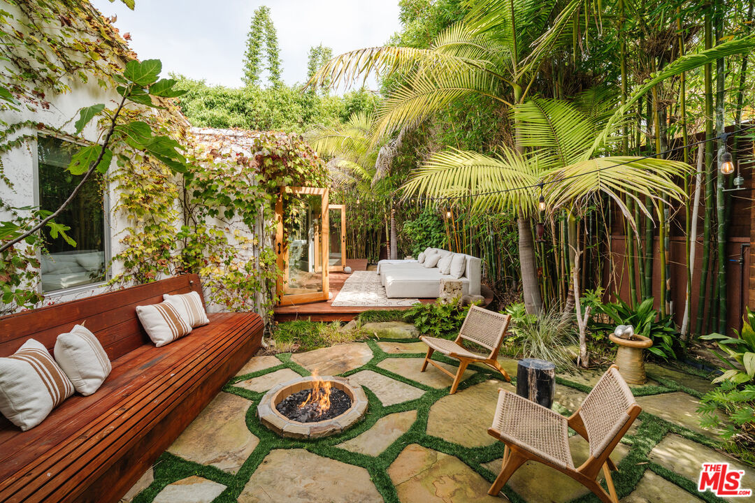 a view of a patio with couches table and chairs and potted plants