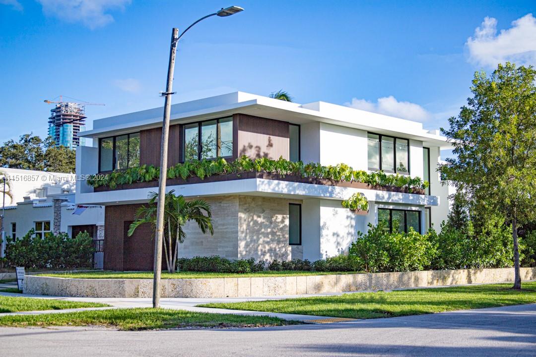 a front view of a house with a garden and plants