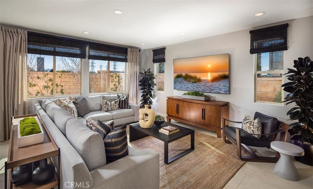 a living room with furniture a flat screen tv and a large window