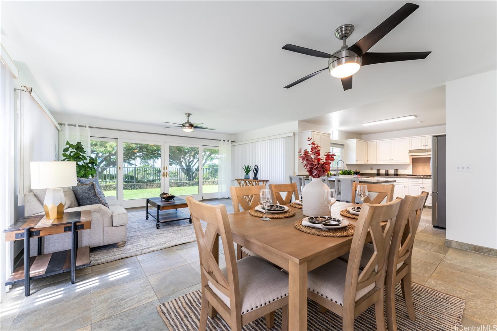 a dining room with wooden floor a chandelier fan a wooden table and chairs