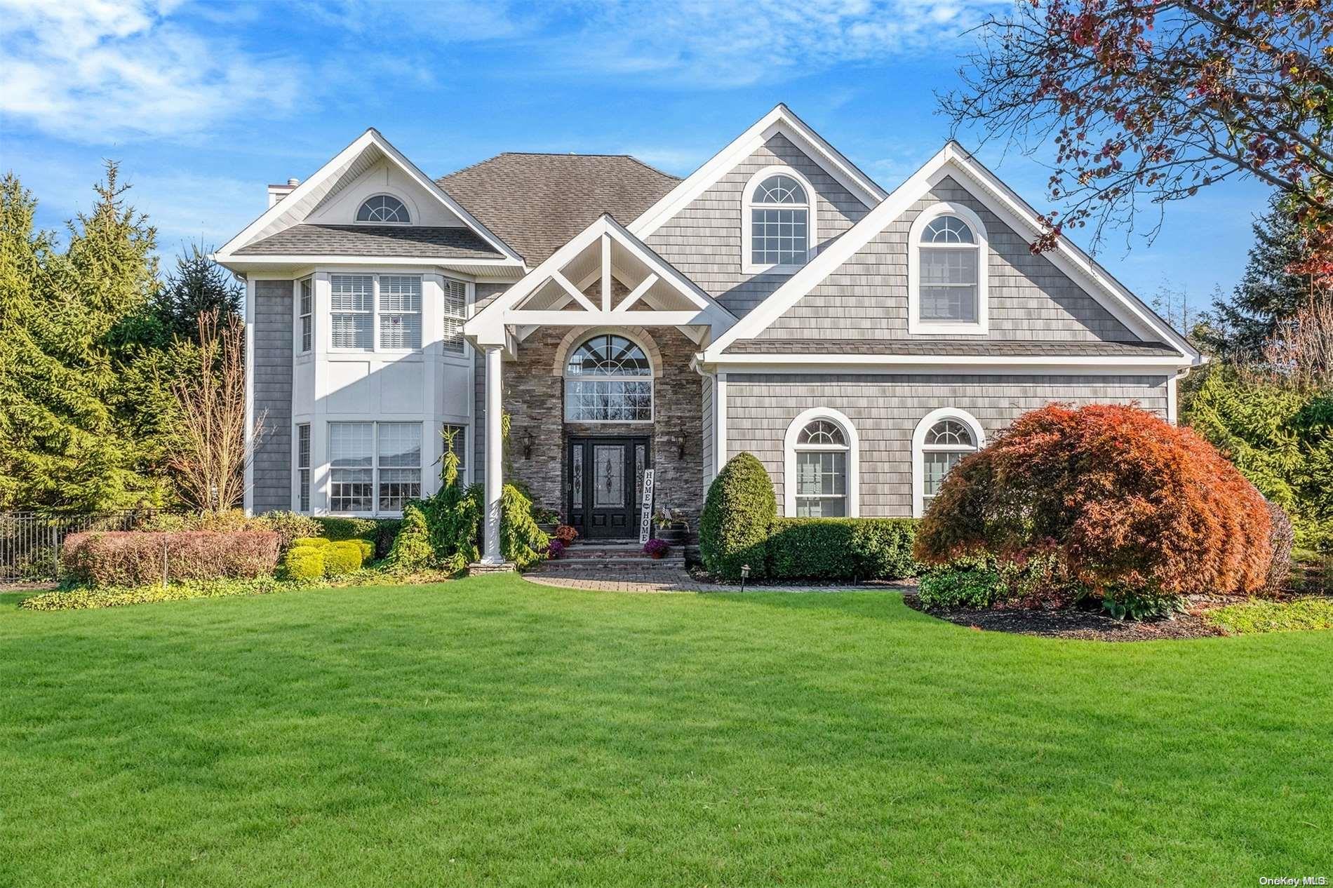 a front view of a house with a yard and trees