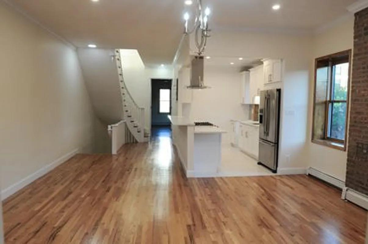 a view of a kitchen with wooden floor and a refrigerator