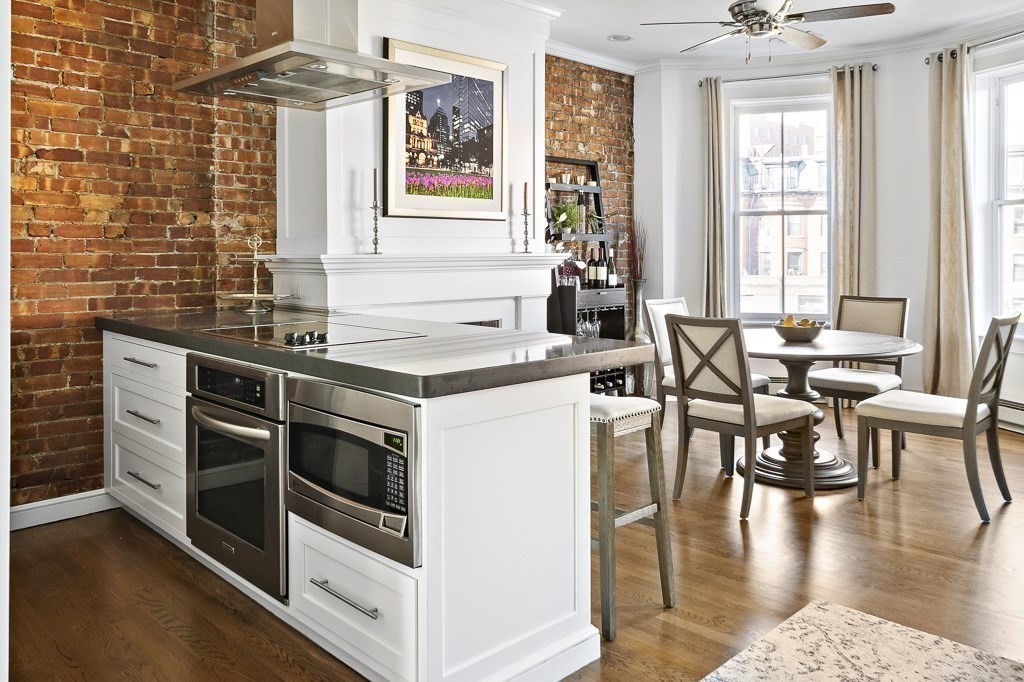 a kitchen with stainless steel appliances wooden floor dining table and chairs