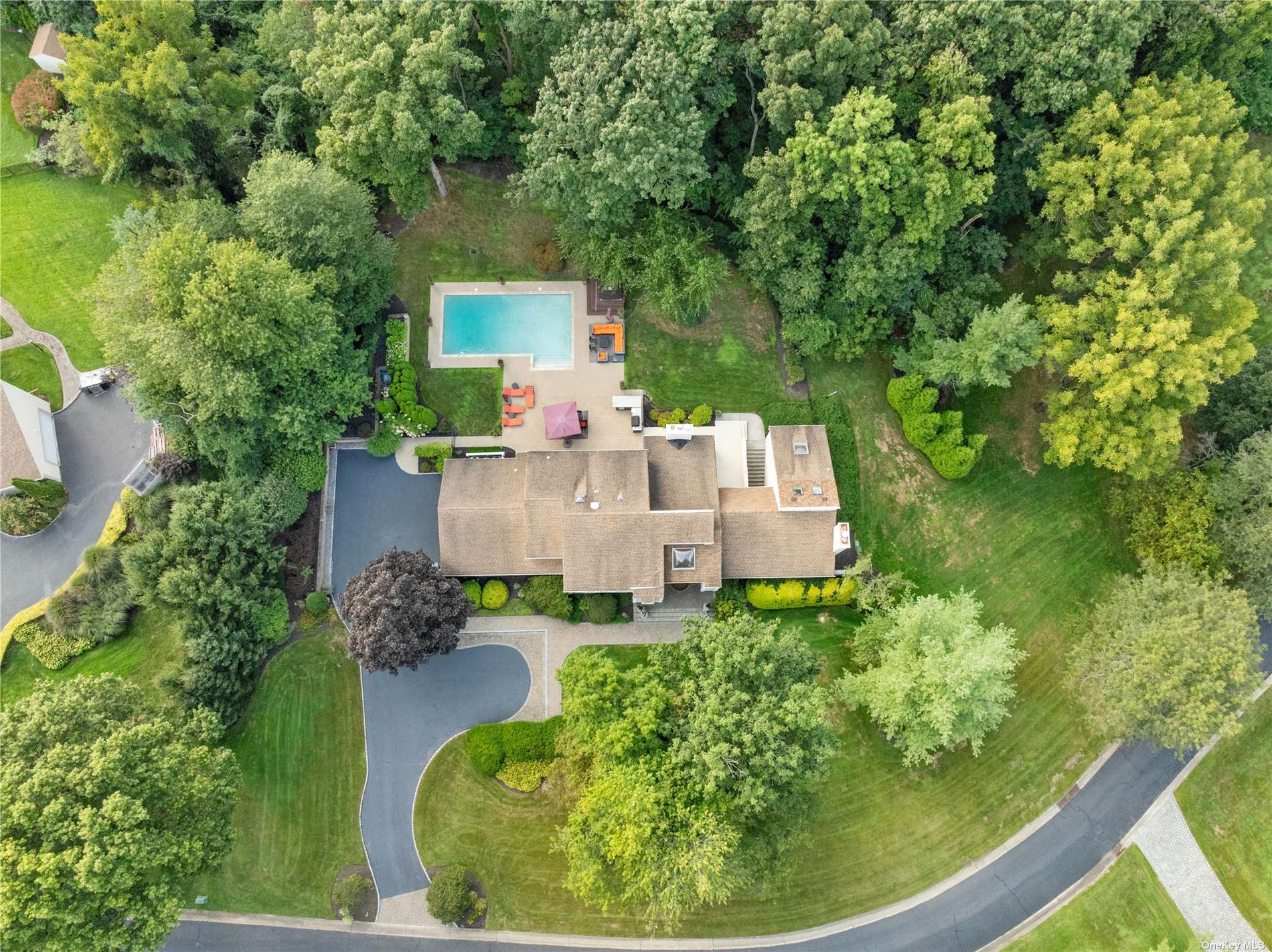 an aerial view of a house with garden space and trees