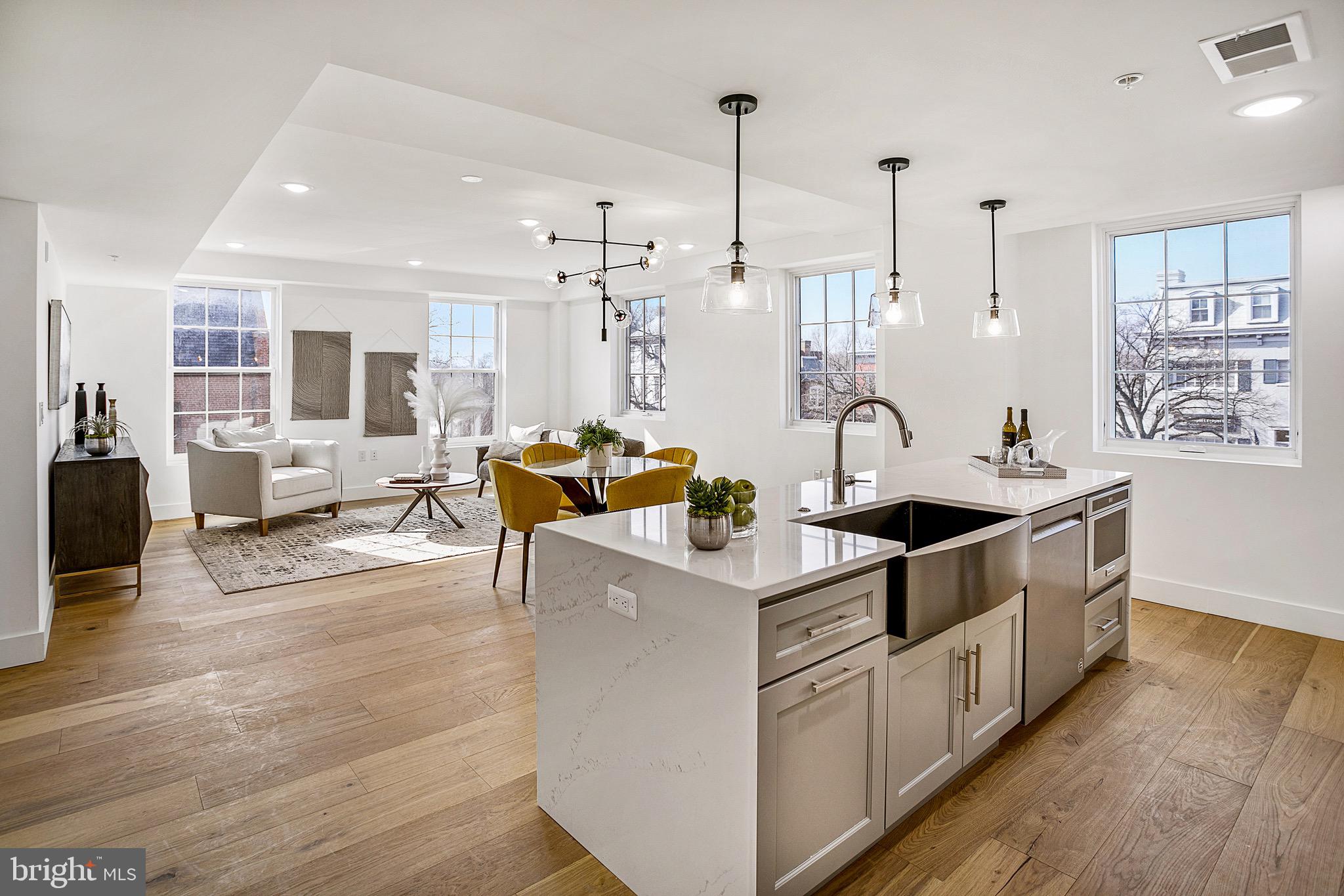 a view of kitchen with stainless steel appliances kitchen island granite countertop a sink and wooden floors