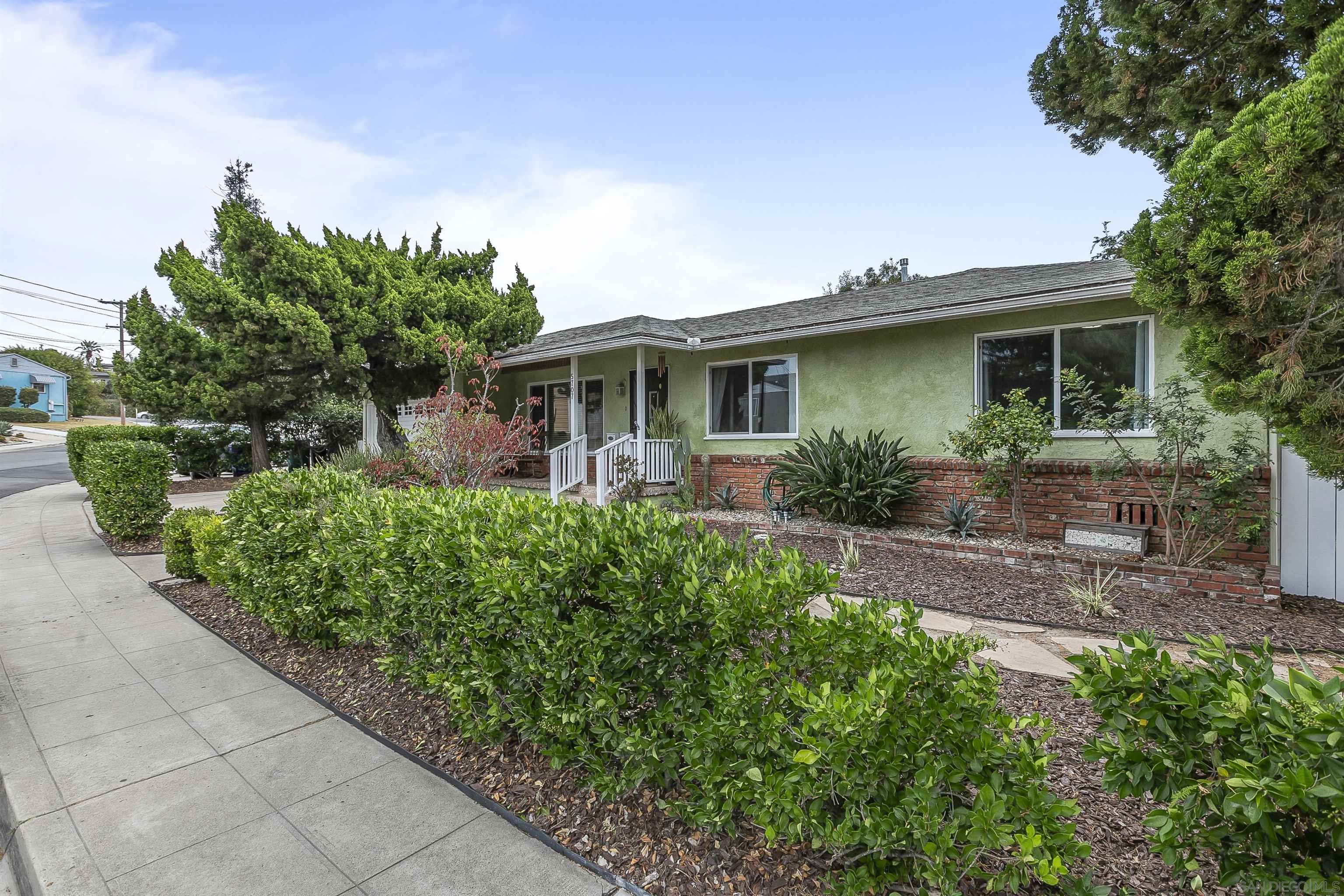 a front view of a house with a yard and potted plants