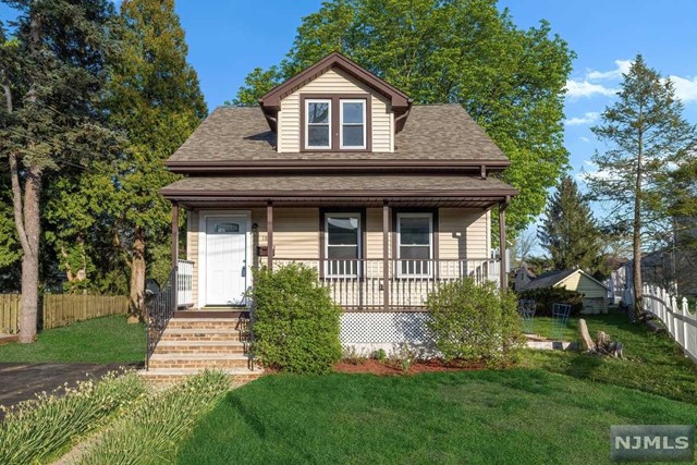 a front view of a house with a yard and potted plants