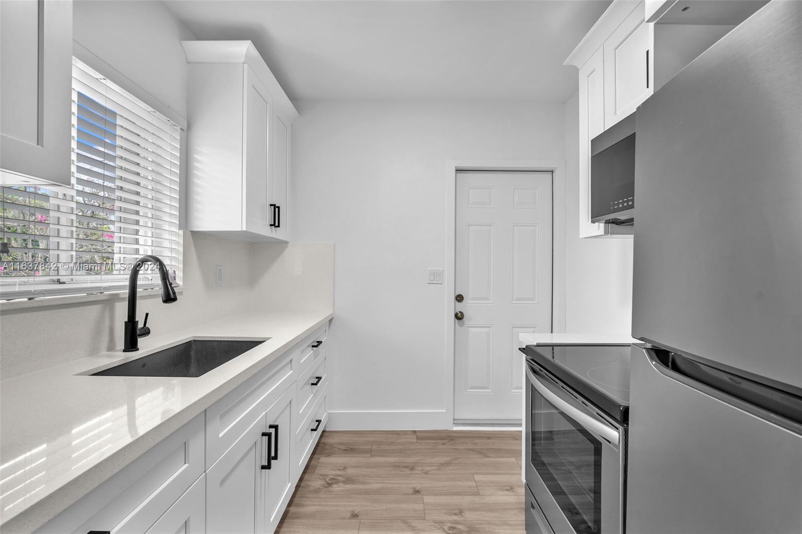 a kitchen with granite countertop white cabinets and sink