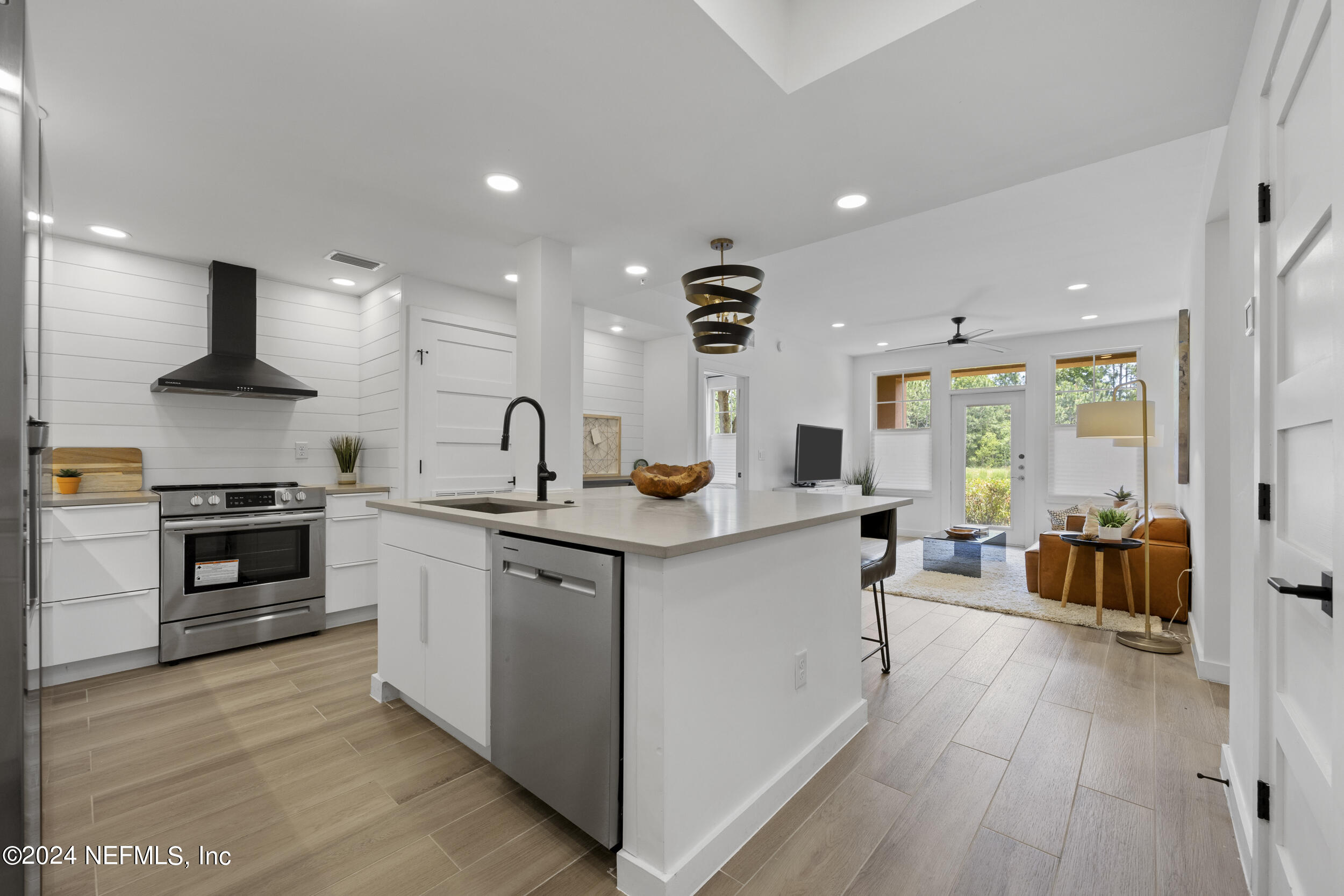 a large kitchen with stainless steel appliances a lot of counter space and a wooden floors