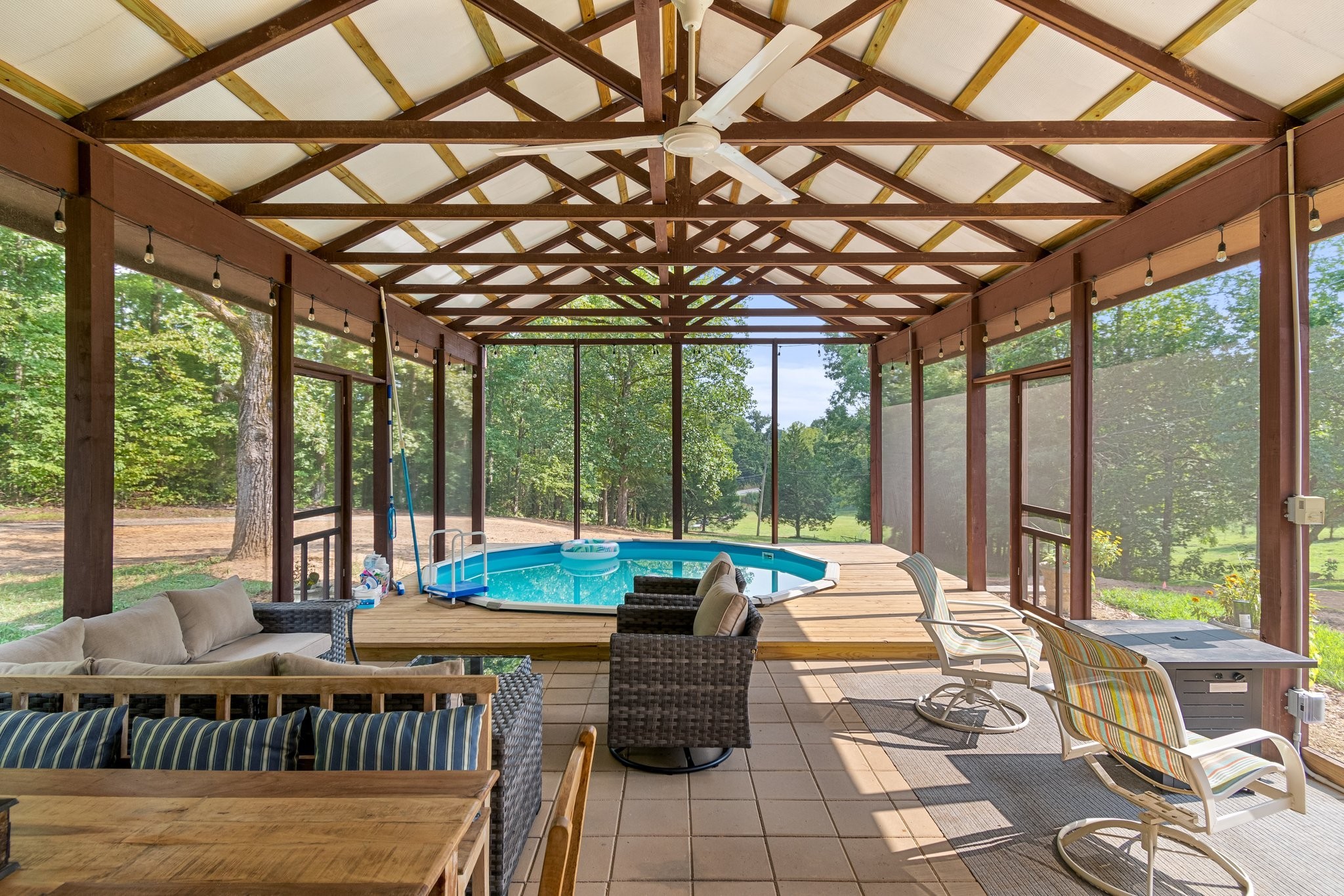 a view of a patio with couches table chairs and wooden floor