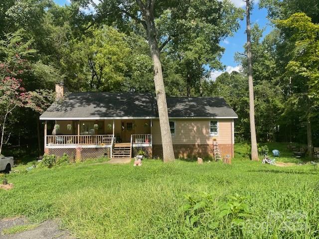 a view of a house with backyard and a large tree