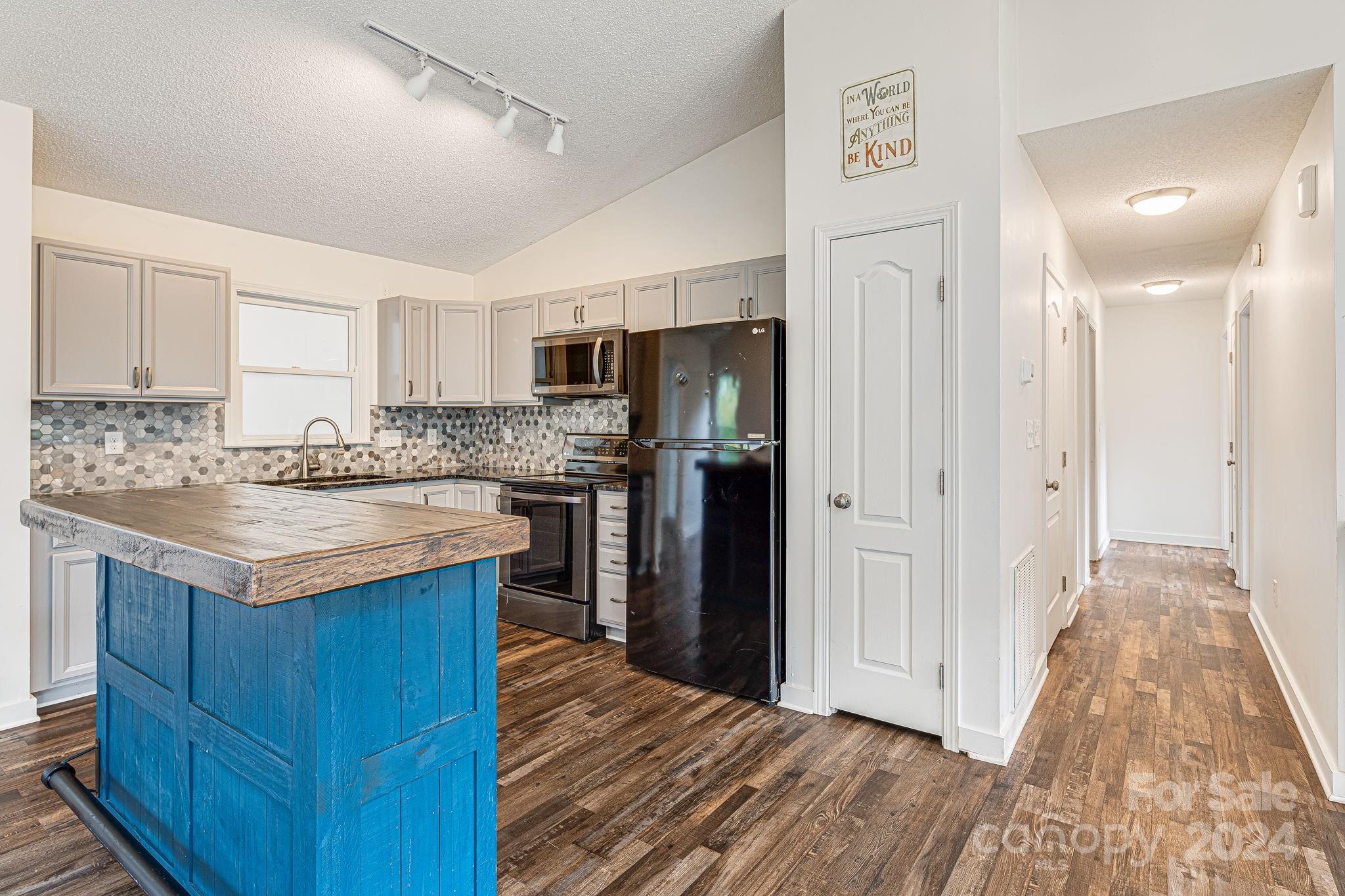 a kitchen with granite countertop a refrigerator and a sink