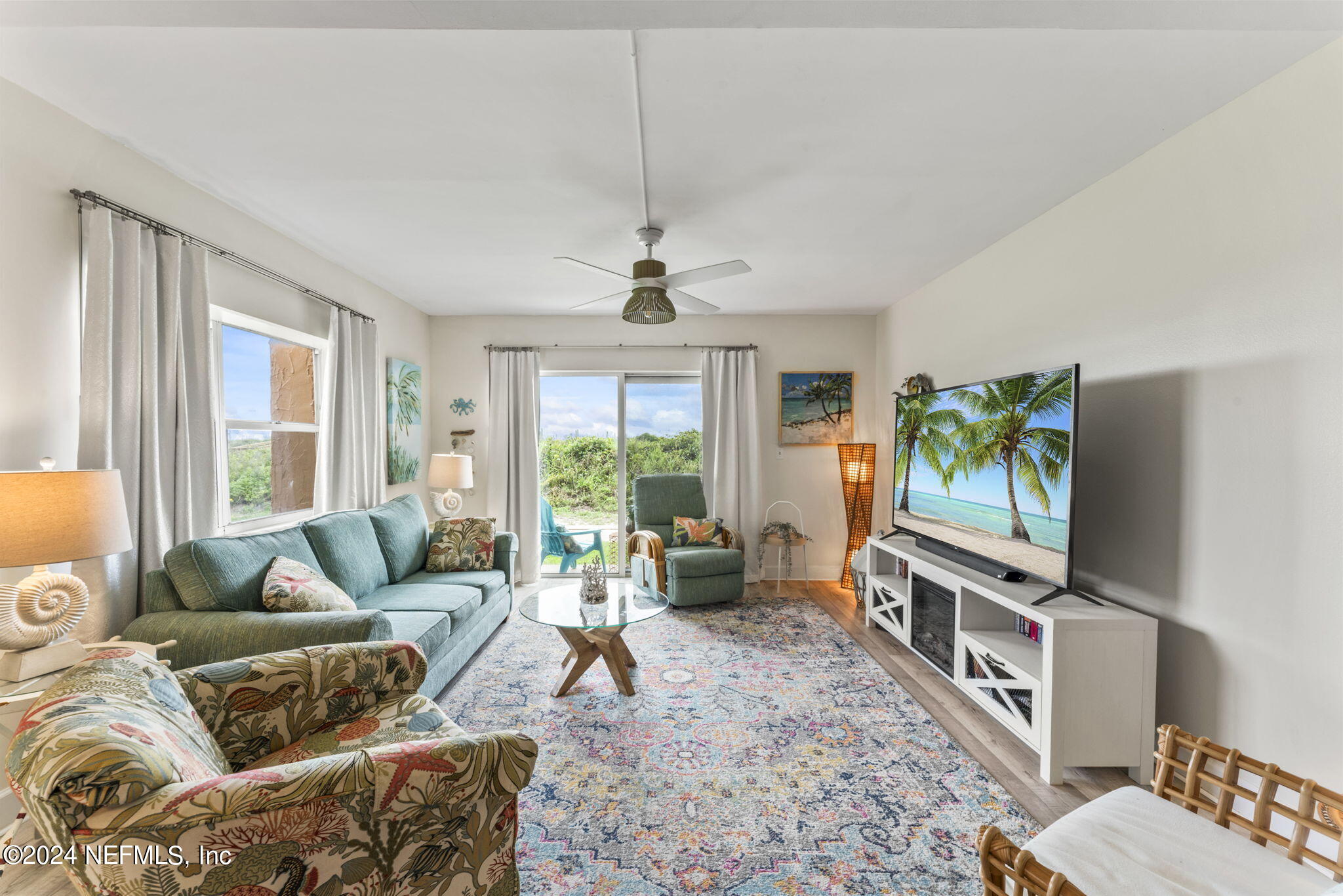 a living room with furniture a window and a flat screen tv