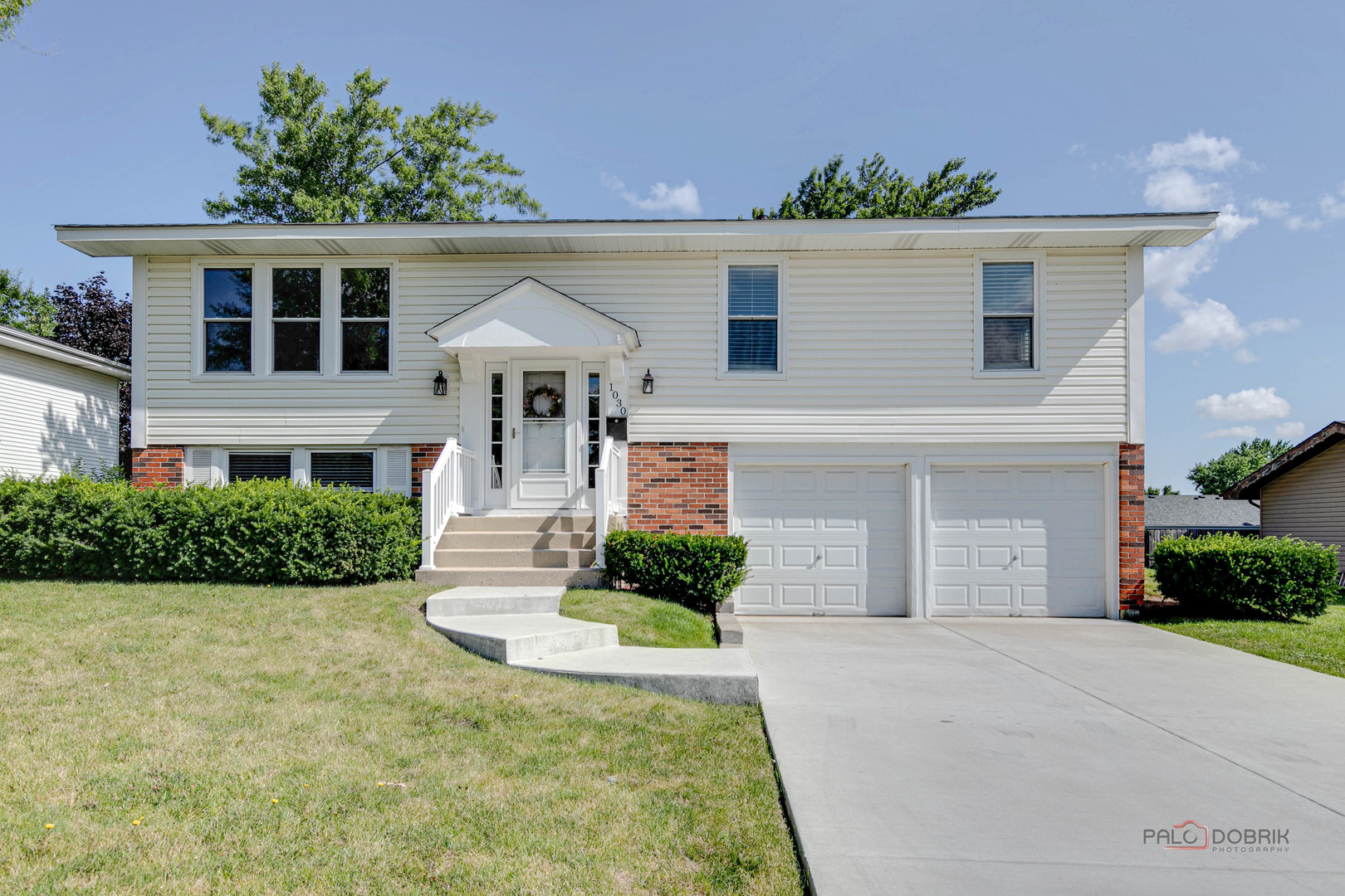 a front view of a house with a yard and garage