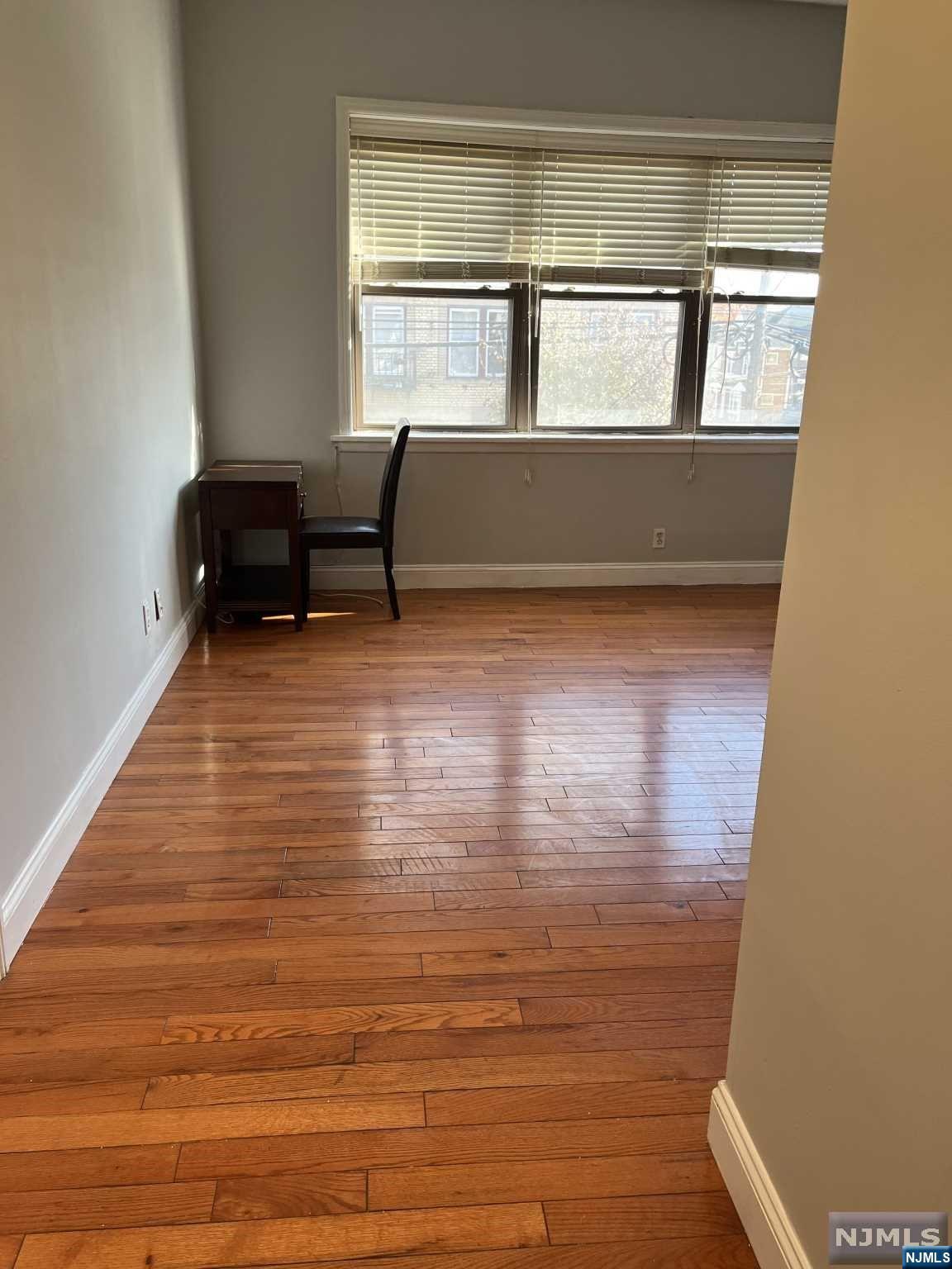 a view of room with window and wooden floor