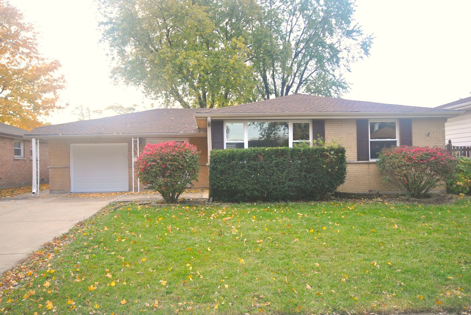 a front view of a house with a garden and yard