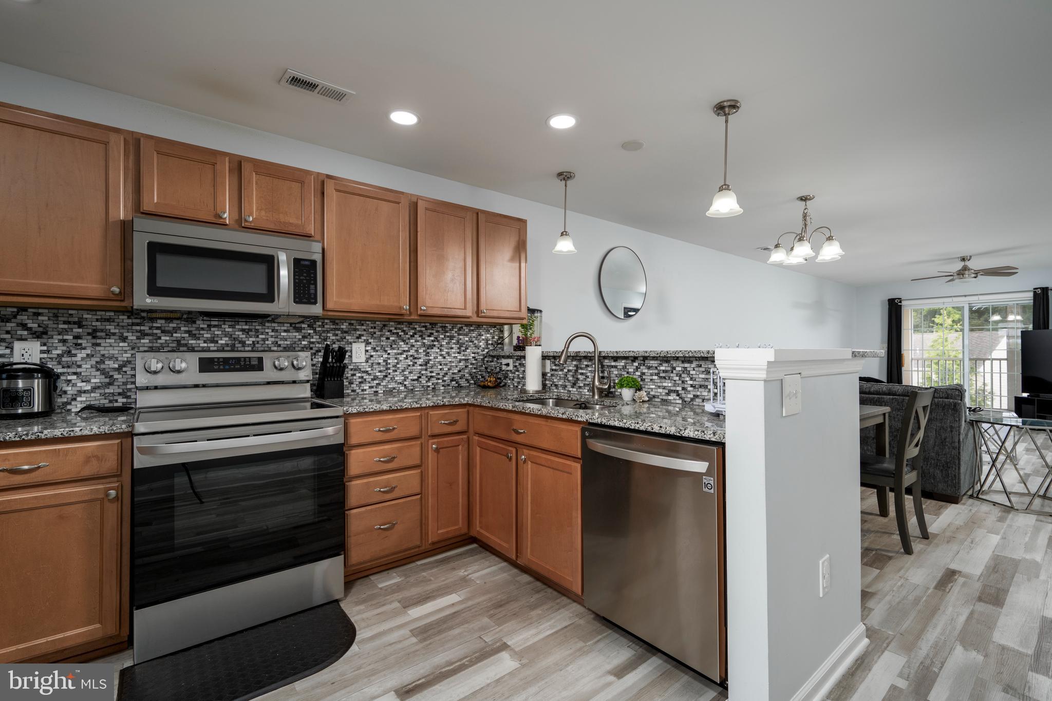 a kitchen with stainless steel appliances granite countertop wooden cabinets and a stove top oven