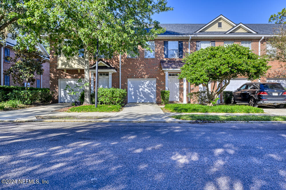 a front view of a house with a garden and trees