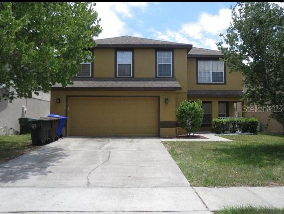 a front view of a house with a yard and trees