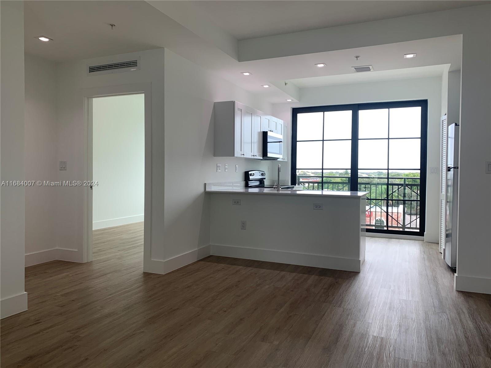 a view of a kitchen with wooden floor and a sink