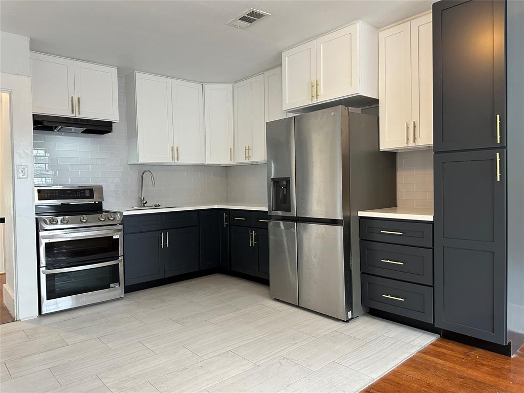 a kitchen with stainless steel appliances granite countertop a refrigerator and a stove