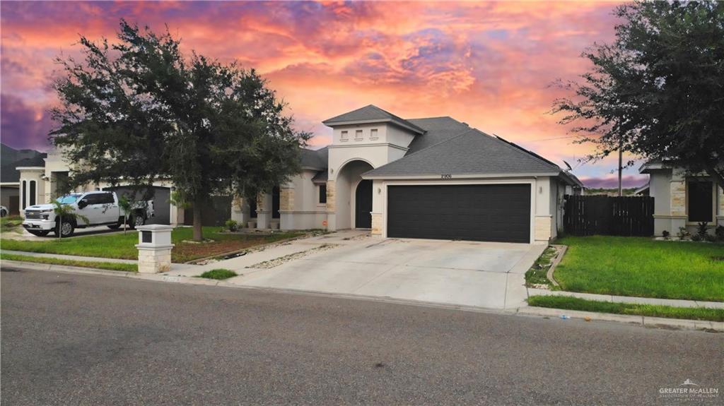 a front view of a house with a yard and garage