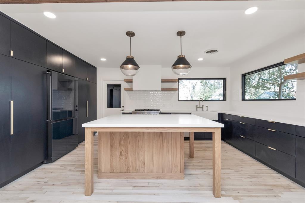 KITCHEN - Absolutely breathtaking this kitchen features state-of-the-art appliances, Quartz countertops, custom built cabinets and island. Notice the lovely Pottery Barn pendants!