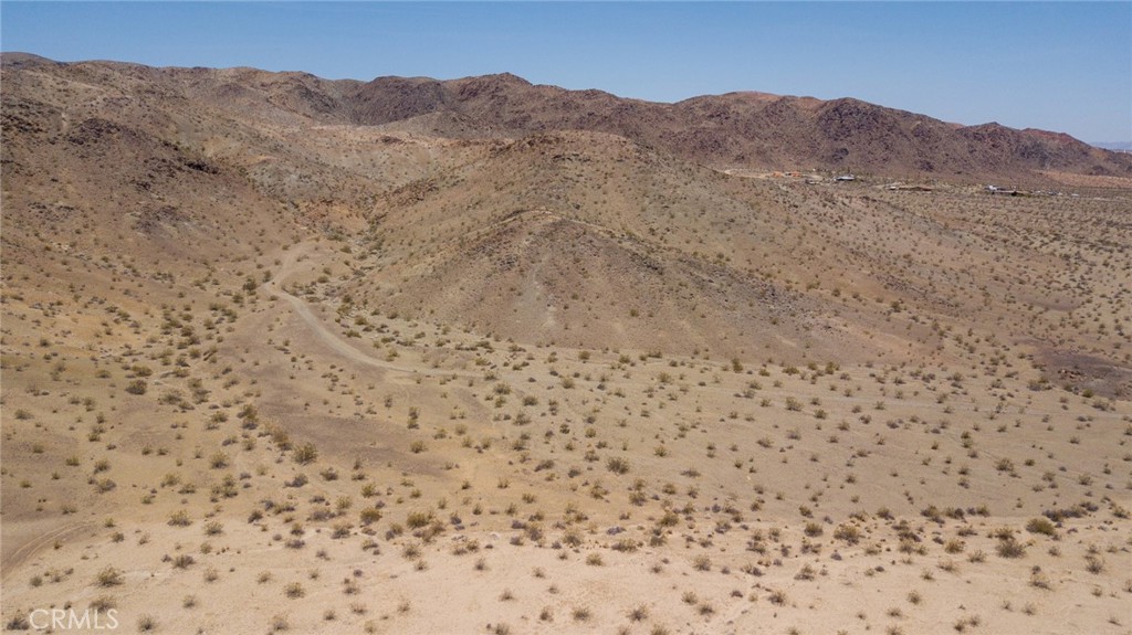 a view of a dry field with mountains in the background