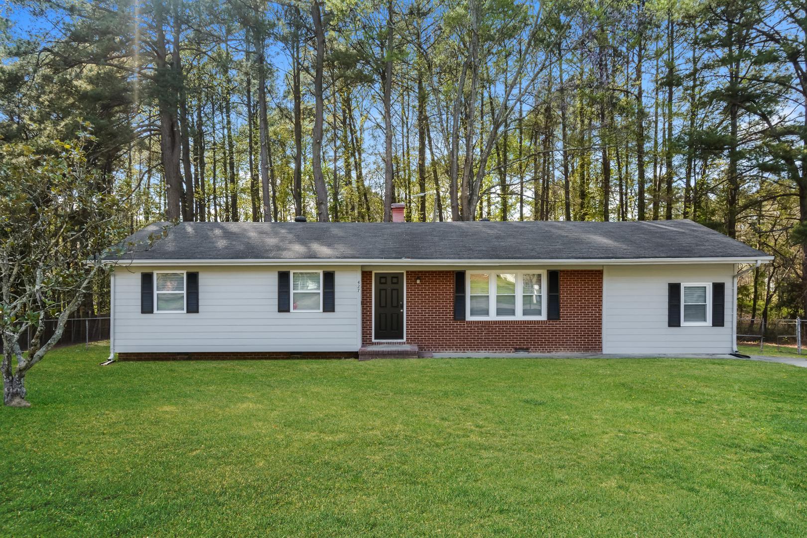 a front view of house with yard and trees