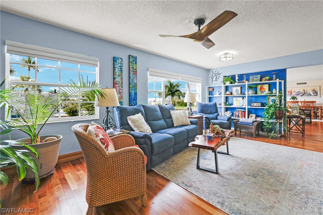 a living room with patio furniture and a wooden floor