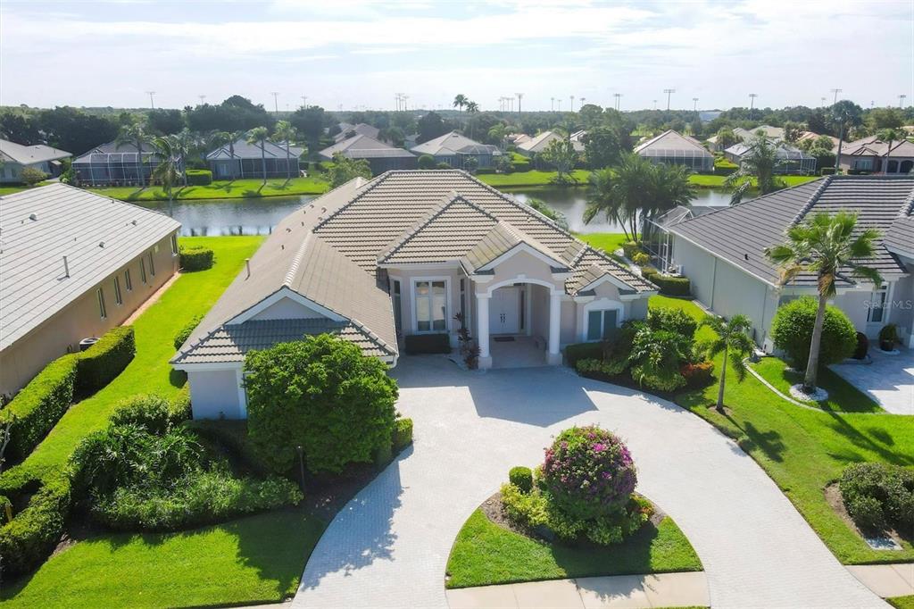 an aerial view of a house with swimming pool garden and lake view