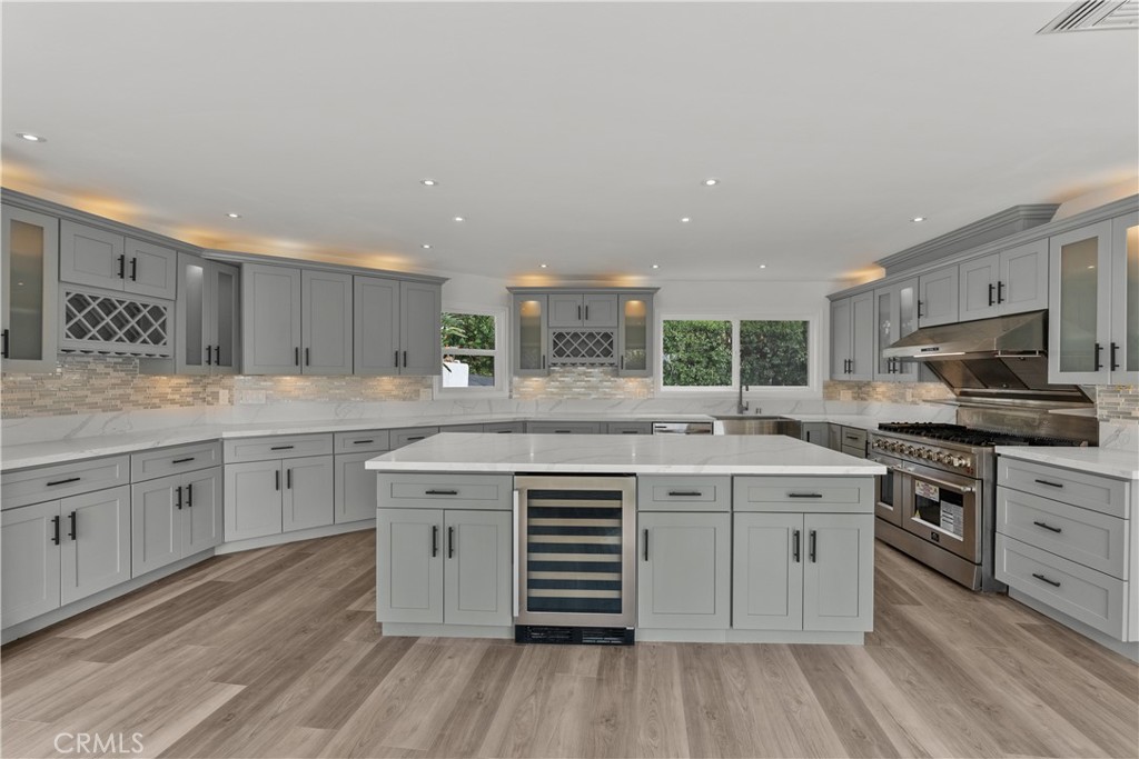 a kitchen with a sink stove cabinets and wooden floor