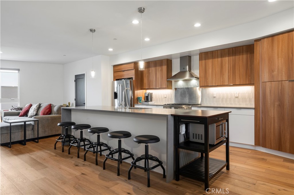 a kitchen with kitchen island granite countertop wooden floors and white cabinets