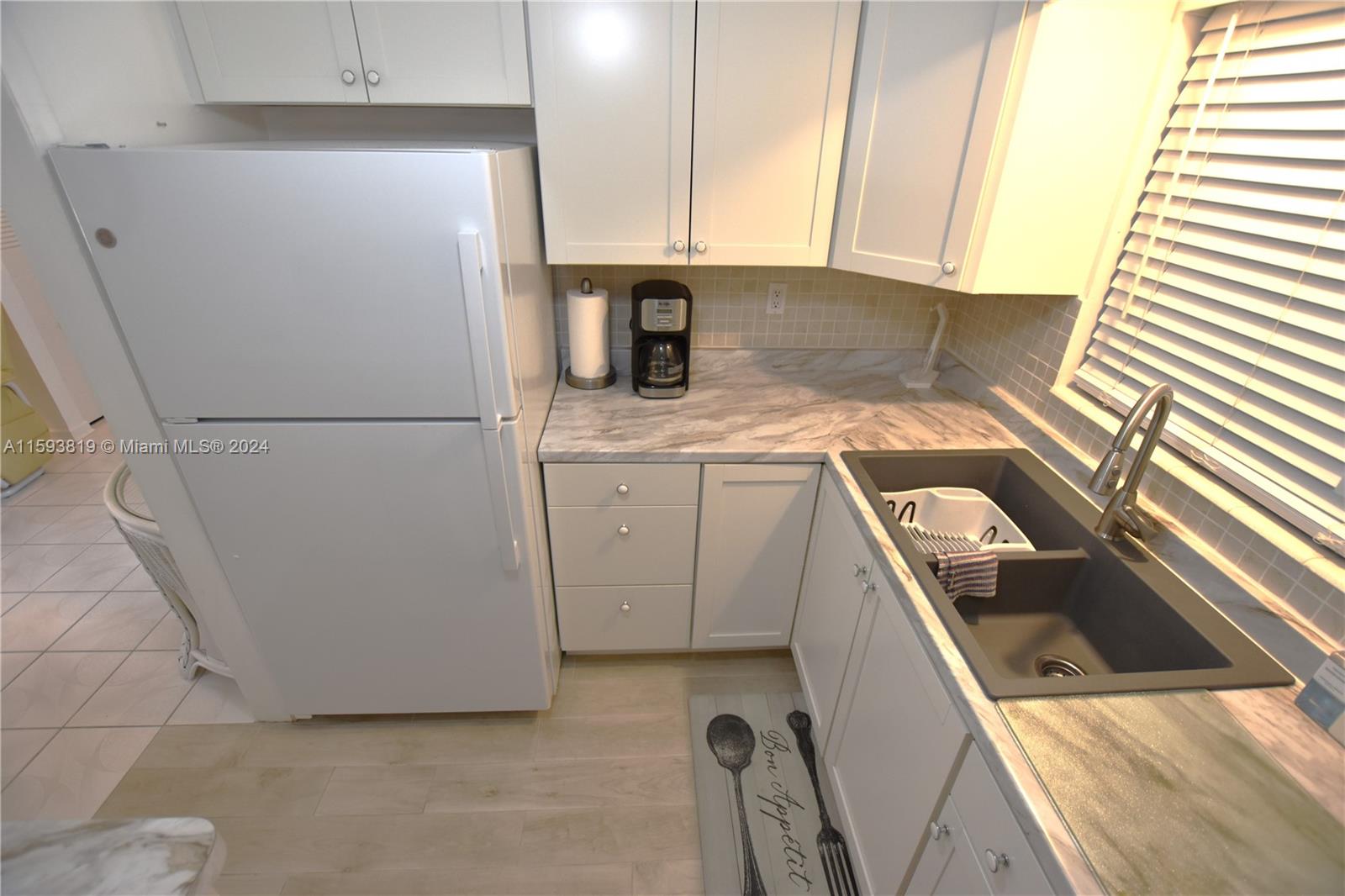 a kitchen with a refrigerator sink stove and cabinets